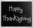 "Happy Thanksgiving" handwritten with white chalk on a blackboar