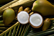 Foto: Whole and opened coconuts on palm leaf Whole and opened coconuts on palm leaf