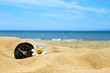 Photo: flower and compass on beach against blue sky flower and compass on beach against blue sky