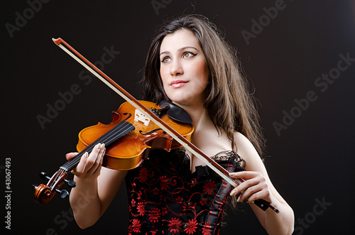 Photo: Female violin player against background Female violin player against background