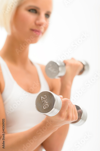 Foto: Woman exercise dumbbells white fitness close-up Woman exercise dumbbells white fitness close-up