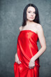 Elegant caucasian woman in red over dark background