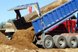 Truck is unloading sand in the road construction
