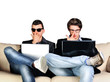 Two young gamers sitting together on sofa and using their laptop
