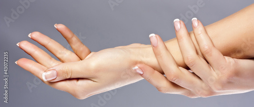 Foto: Woman hands on grey background, isolated Woman hands on grey background, isolated