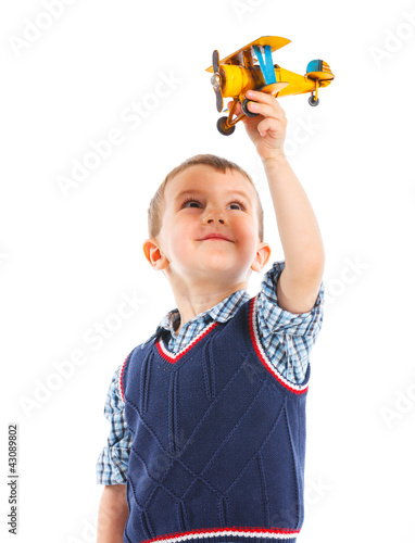 Foto: Cute little boy playing with a toy airplane Cute little boy playing with a toy airplane