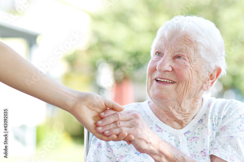 Foto: Senior woman holding hands with caretaker Senior woman holding hands with caretaker