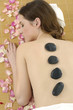 Photo: young woman getting a stone massage in spa young woman getting a stone massage in spa