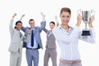 Close-up of a woman holding a cup with people dressed in suits a