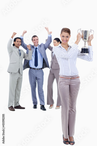 Photo: Woman holding a cup with people dressed in suits acclaiming Woman holding a cup with people dressed in suits acclaiming