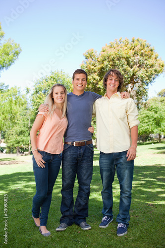 Photo: Three smiling students standing Three smiling students standing