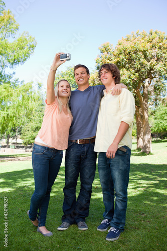 Photo: Three smiling students taking a pictures of themselves Three smiling students taking a pictures of themselves
