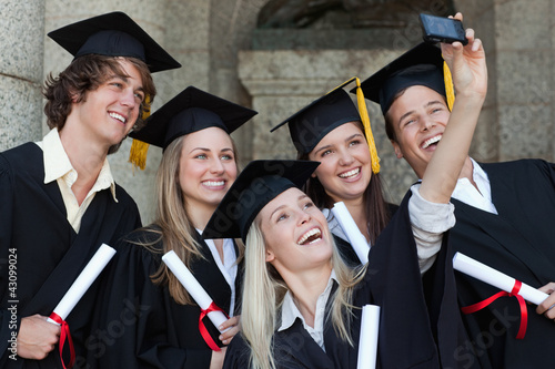 Photo: Close-up of happy graduates taking a picture of themselves Close-up of happy graduates taking a picture of themselves