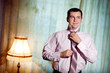 handsome man putting on a necktie