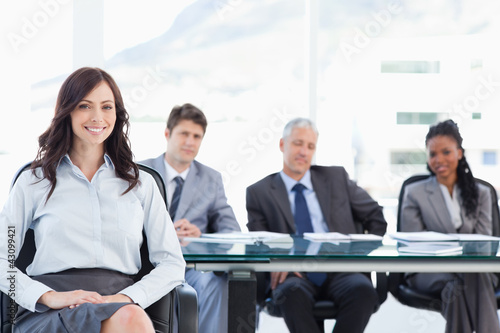 Photo: Young businesswoman sitting with her hand on her leg and accompa Young businesswoman sitting with her hand on her leg and accompa