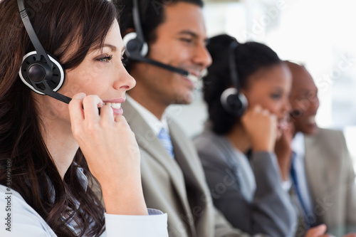 Photo: Young businesswoman working with a headset and accompanied by he Young businesswoman working with a headset and accompanied by he