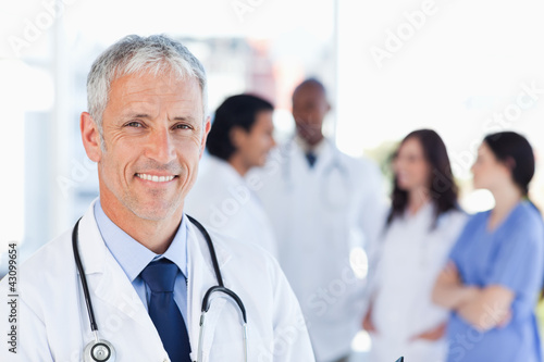 Foto: Mature doctor standing upright while waiting for his team Mature doctor standing upright while waiting for his team