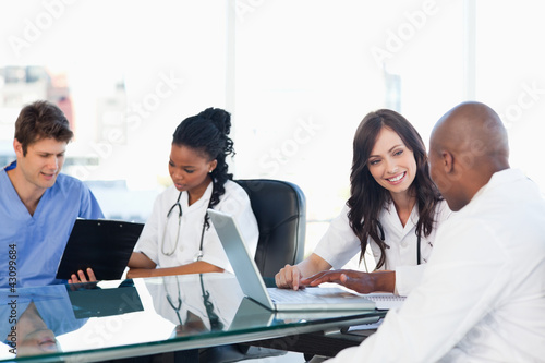 Photo: Medical team working on both a laptop and a clipboard Medical team working on both a laptop and a clipboard