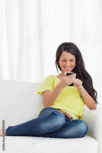 Photo: Happy Latino looking her smartphone Happy Latino looking her smartphone