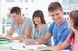 A girl looks into the camera smiling as the other friends help e