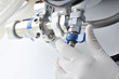Work with medical gases. Hand of specialist untwists oxygen cyli