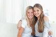 A pair of sisters hug each other as they look into the camera