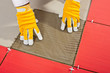 Photo: worker with a glass tile demonstrates how the tile adhesive work worker with a glass tile demonstrates how the tile adhesive work