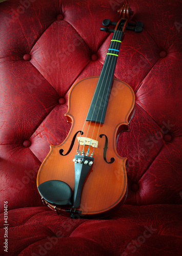 Photo: violin on luxury red leather background violin on luxury red leather background