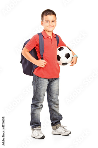 Photo: Full length portrait of a child with backpack holding a ball Full length portrait of a child with backpack holding a ball
