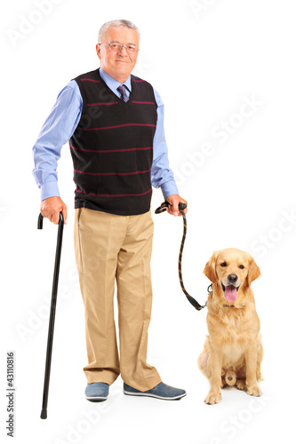 Foto: Full length portrait of a senior man holding a cane and a dog Full length portrait of a senior man holding a cane and a dog