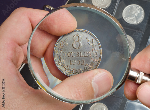 Photo: The numismatist examines a coin from the collection The numismatist examines a coin from the collection