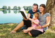 Happy family with books on the nature near lake
