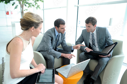 Photo: Business people meeting in trade fair building hall Business people meeting in trade fair building hall