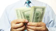 Businessman counts money in hands.