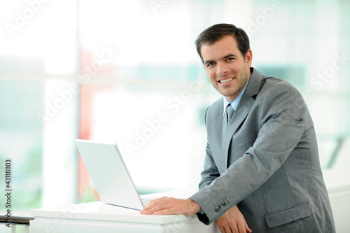 Foto: Businessman using laptop computer in entrance hall Businessman using laptop computer in entrance hall