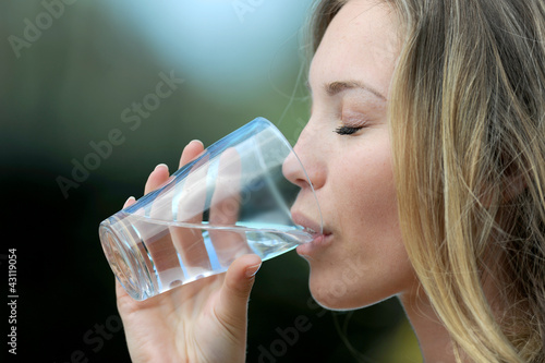 Photo: Closeup of blond woman drinking water from glass Closeup of blond woman drinking water from glass