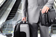Photo: Businessman with his luggage near an escalator at an airport Businessman with his luggage near an escalator at an airport