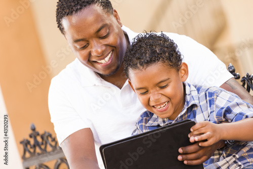 Foto: Mixed Race Father and Son Using Touch Pad Computer Tablet Mixed Race Father and Son Using Touch Pad Computer Tablet