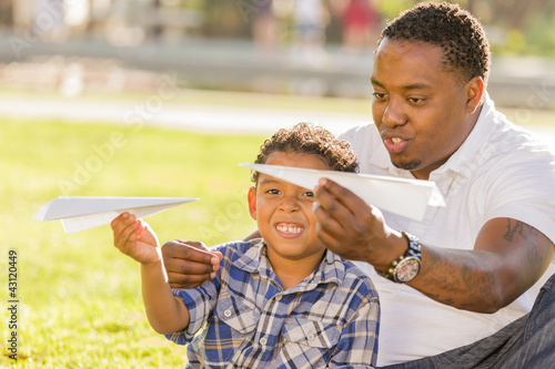 Photo: Mixed Race Father and Son Playing with Paper Airplanes Mixed Race Father and Son Playing with Paper Airplanes