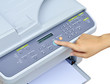 Hand pressing Start button on printer