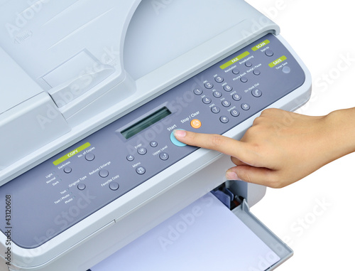 Photo: Hand pressing Start button on printer Hand pressing Start button on printer