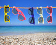 Foto: Collection of sunglasses on the beach Collection of sunglasses on the beach