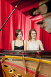 Pretty girls play two part harmony on a piano