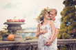 A couple in love during pregnancy in the park with fruit and mel