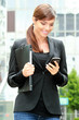 Photo: Femme d'affaire arrivant au bureau en lisant ses mails Femme d'affaire arrivant au bureau en lisant ses mails