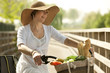 Woman cicyling with vegetables on her basket