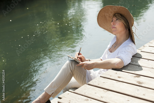 Photo: Woman reading by the river Woman reading by the river