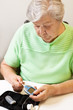Photo: Seniorin schiebt Teststreifen in das Blutzuckermessgerät Seniorin schiebt Teststreifen in das Blutzuckermessgerät