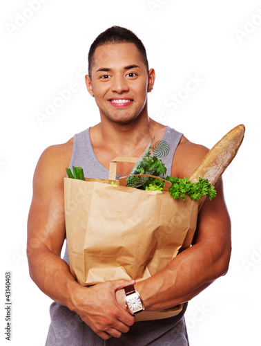 Photo: Portrait of muscle man posing in studio with food Portrait of muscle man posing in studio with food