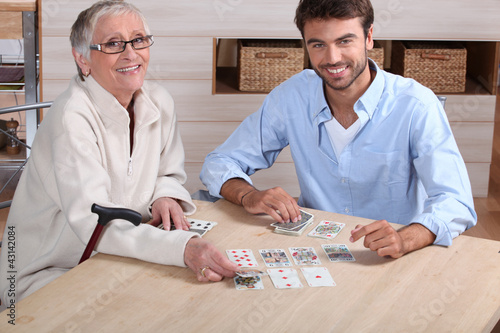 Photo: Young playing cards with senior woman Young playing cards with senior woman